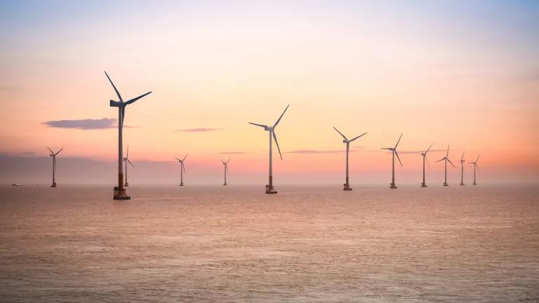 Turbines at an offshore wind farm in the East China Sea, at sunset.