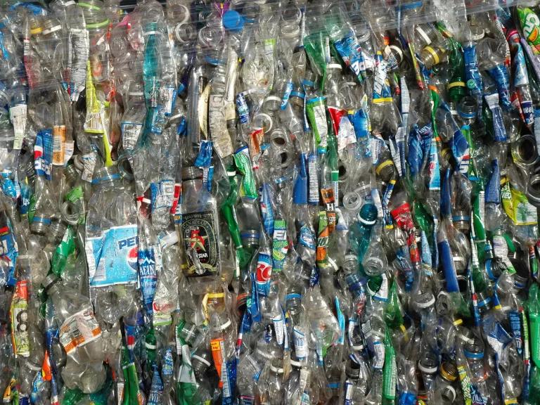 Thousands of plastic bottles are crushed and packed for disposal.
