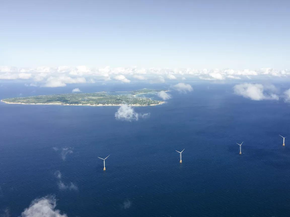 An aerial view of turbines in the Atlantic Ocean offshore of Block Island, Rhode Island, seen through wispy clouds