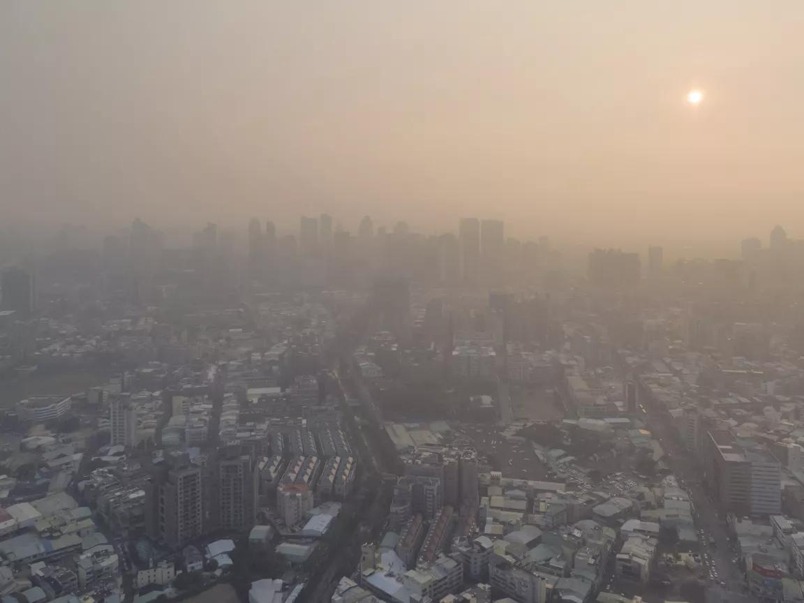 An aerial view of a city is obscured by thick haze.