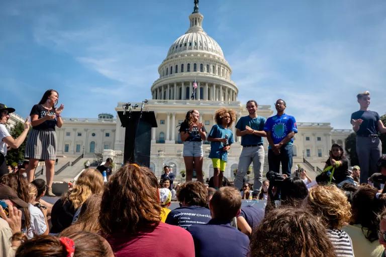 A group of people addresses a crowd in front of the U.S. Capitol