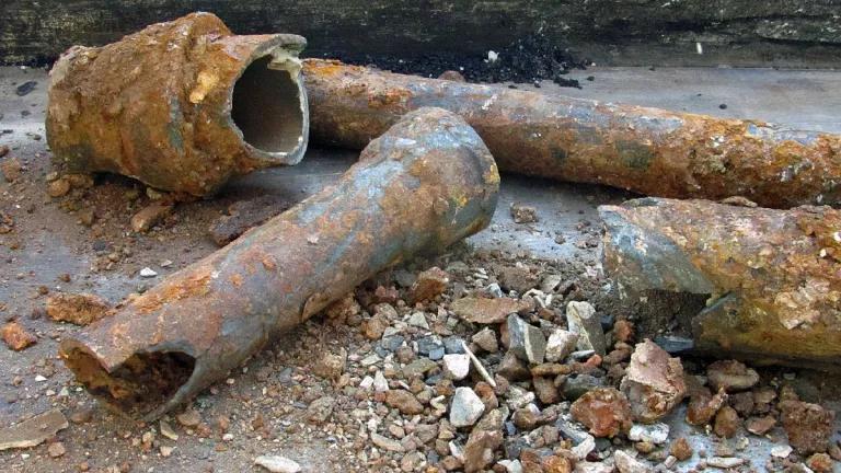 Rusty water pipes sit broken after being pulled up from underground