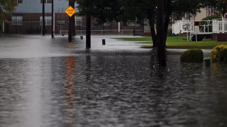 A flooded neighborhood street ends with a "dead end" sign.