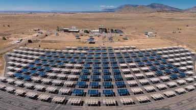 A panoramic aerial view of a solar panel array at Sandia National Laboratories in Albuquerque, New Mexico
