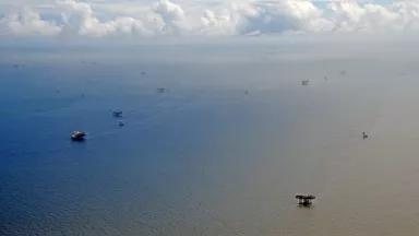 Oil facilities dot a vast expanse of ocean