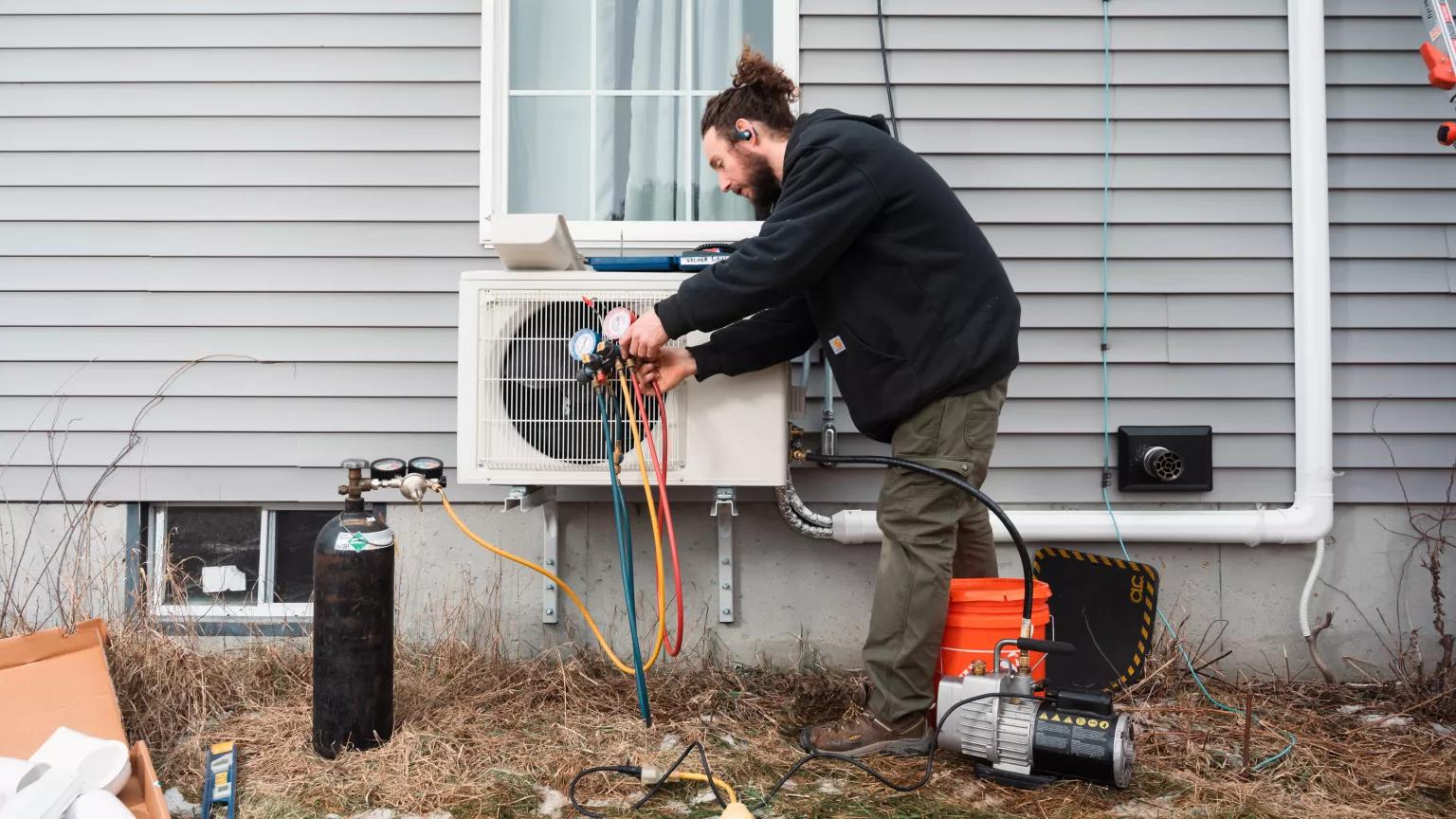 ReVision Energy HVAC technician Matt Johnson working on removing all moisture from the line set of an newly installed electric heat pump on a home in Windham, Maine on January 19, 2023.