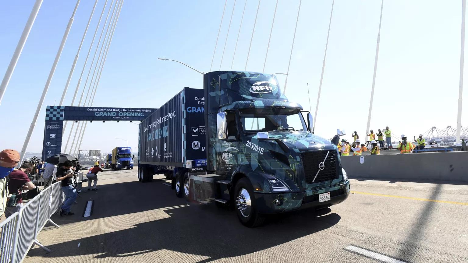 A blue 18-wheeler truck on a bridge