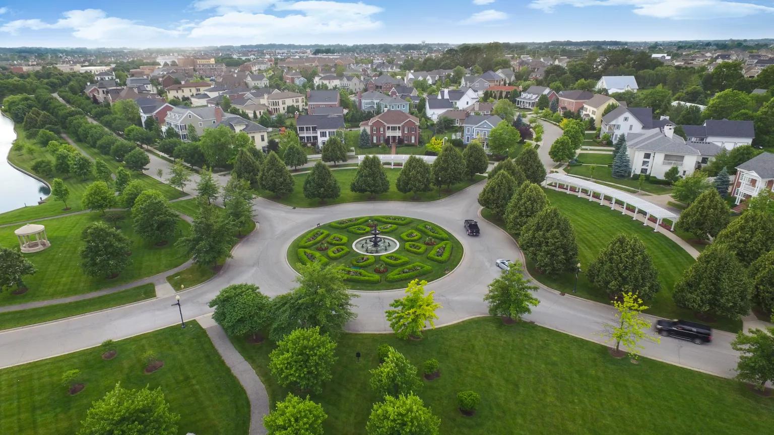 An aerial view of a traffic circle in a landscaped neighborhood