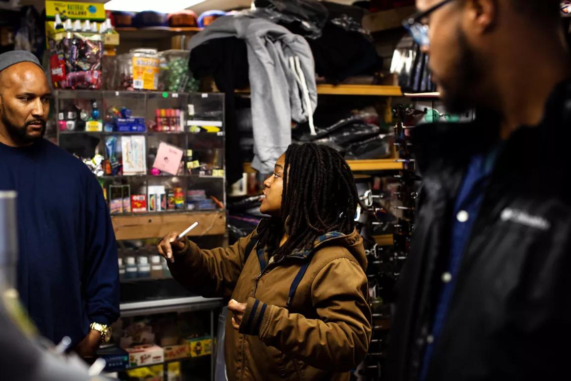 A woman talks to two men in a store
