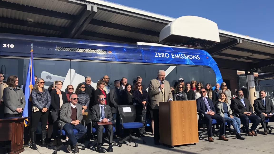 Gov. Sisolak speaking at a press conference in front of an electric bus