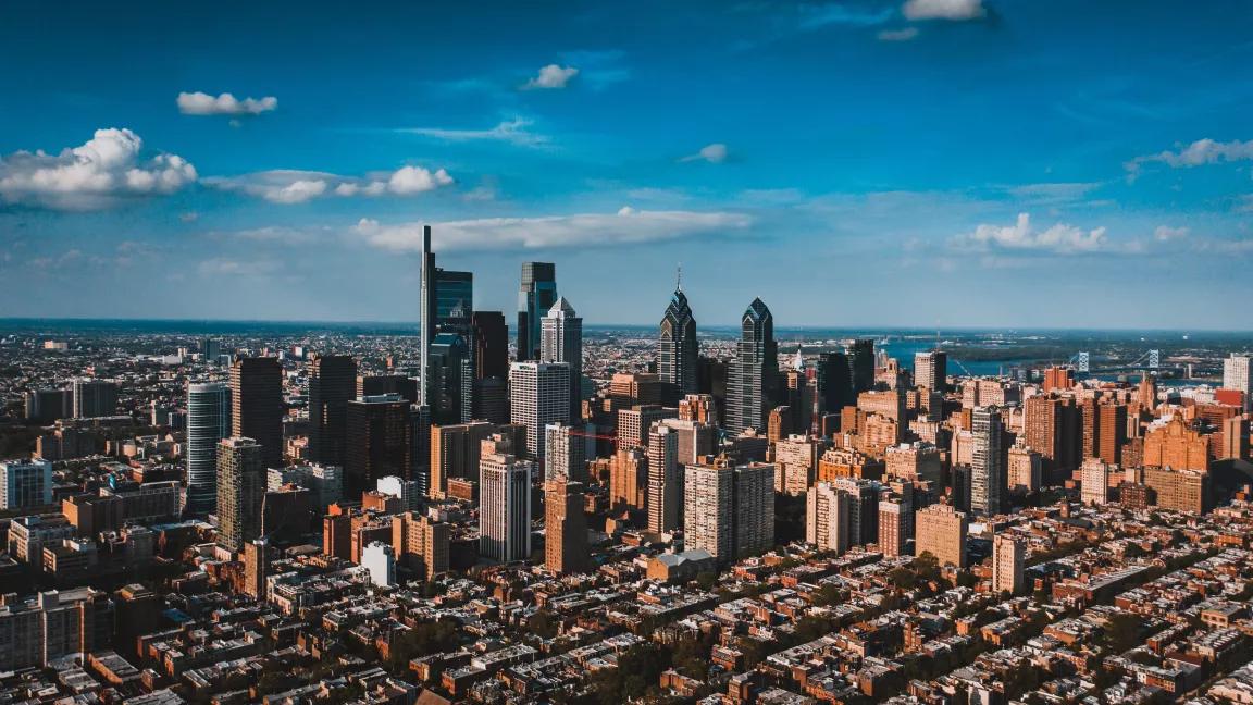 Cityscape of Philadelphia with residential area and downtown, bright blue sky