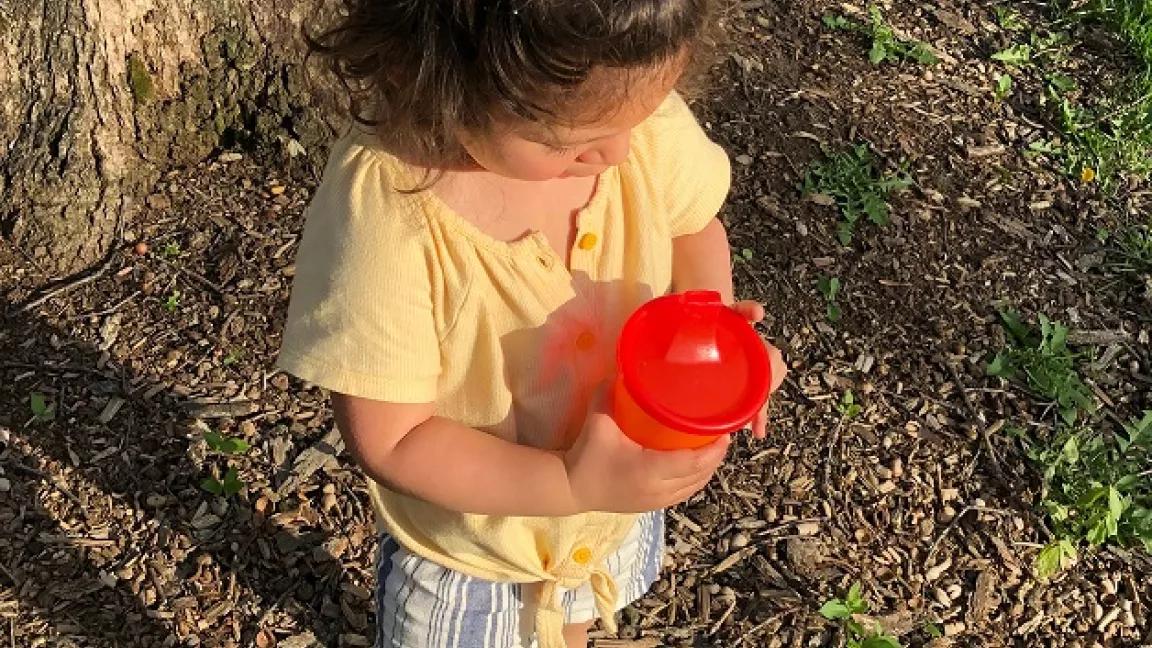 Photo of a child and her sippy cup of water
