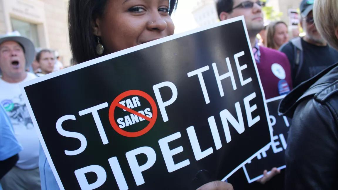 Young Black Woman with Stop the Pipeline Sign