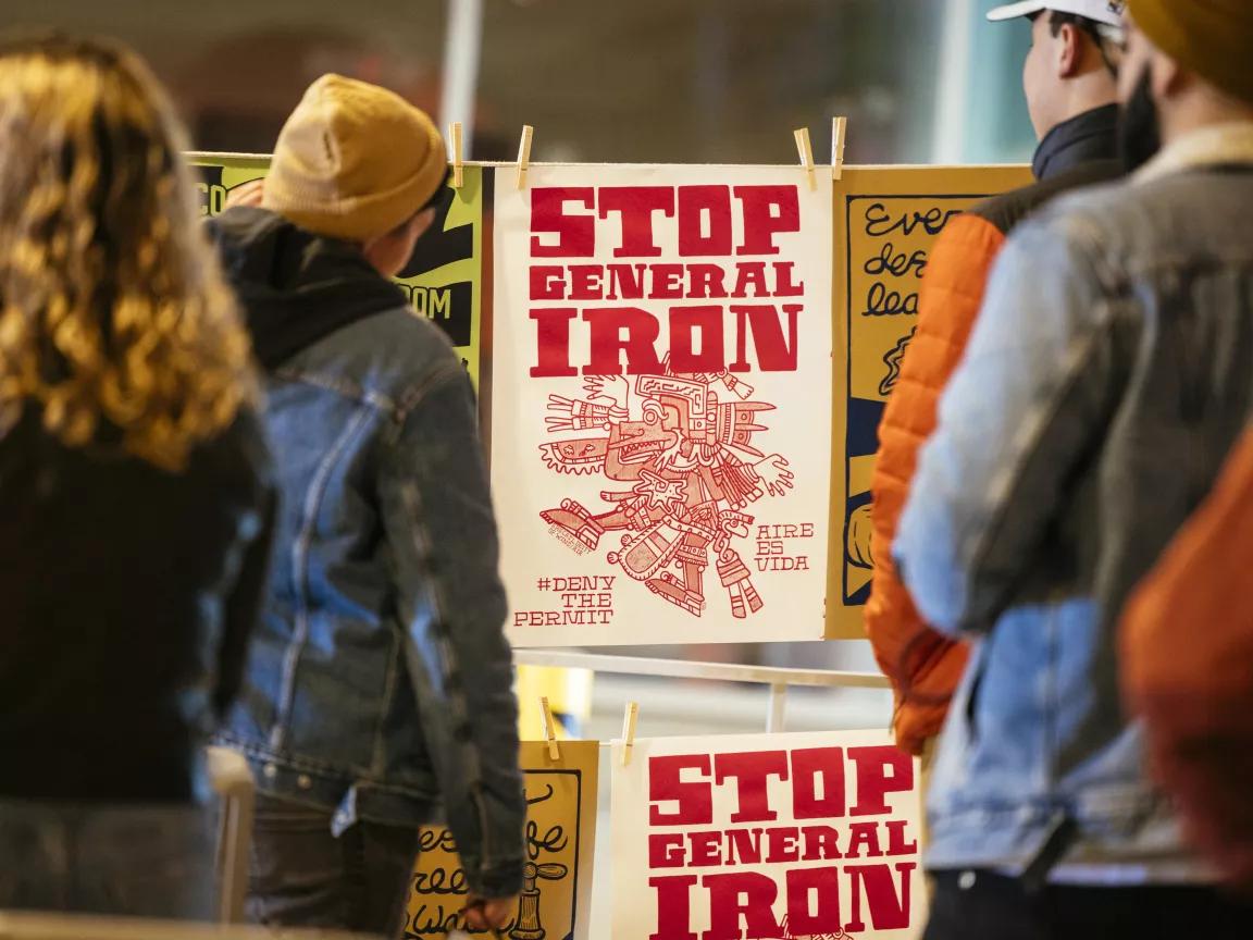 Artist Grae Rosa (second from left) viewing their "Stop General Iron" artwork at the NRDC exhibit during EXPO CHICAGO at Navy Pier in Chicago, April 10, 2022