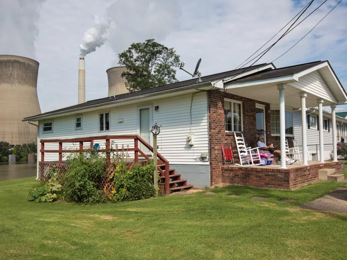 Carl Allison on the porch of his home in Poca, West Virginia, across from the coal-fired John E. Amos Power Plant.