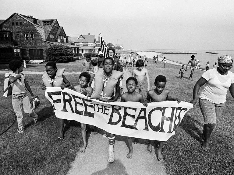 Young members of the Revitalization Corps holding a banner that reads “Free the Beach”