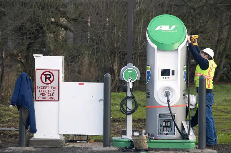 A worker assembling an electric vehicle charging station in Lane County, Oregon.