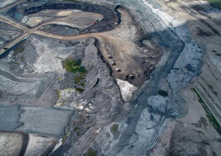 Acres of land in a tar sands operation appear gray and barren from above