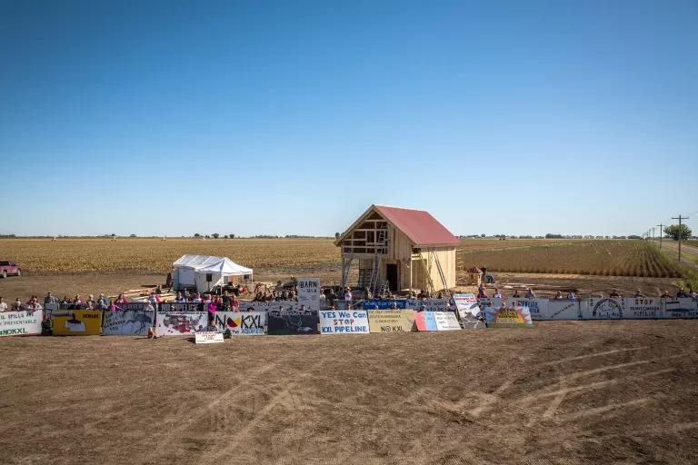 People standing next to a barn being 