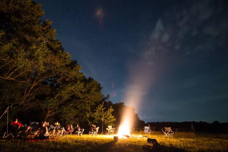 People sitting around a campfire in a Michigan forest