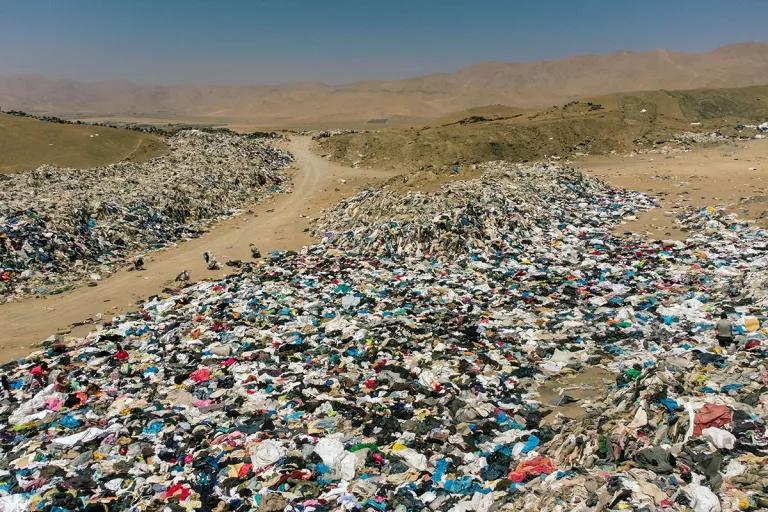 A vast clearing in a valley is strewn with massive piles of clothing 