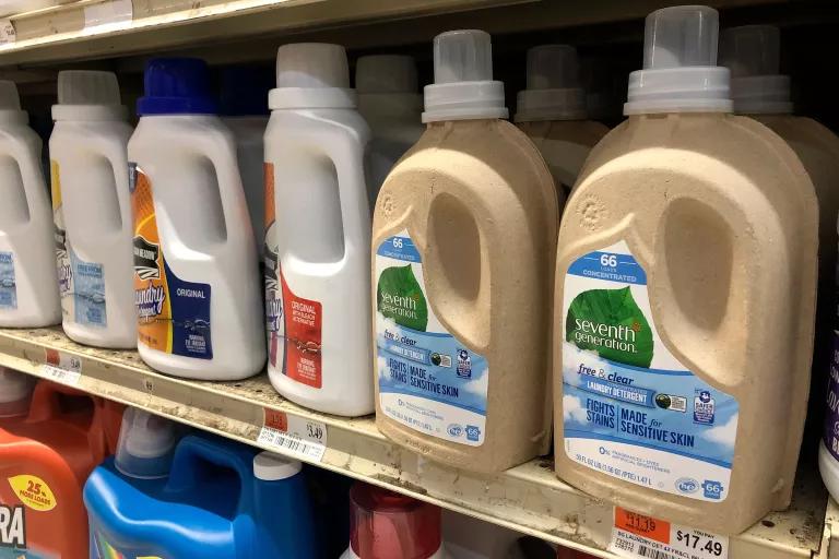 Large plastic jugs of laundry detergent on a grocery store shelf