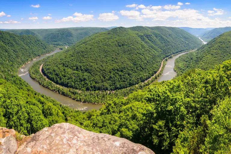 A bend in the Ohio River surrounded by lush green hills