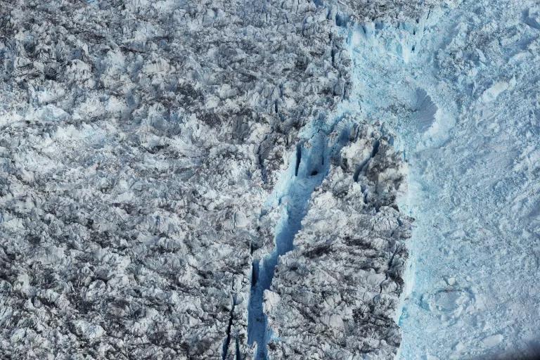 An aerial view of a vast surface of ice with a cleave near the center