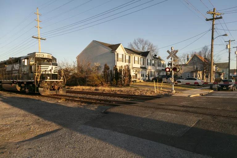 A train passes by residential homes