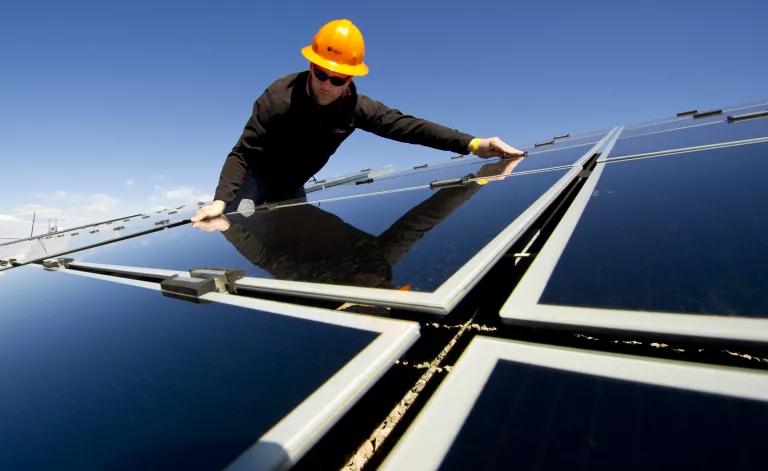 Construction worker testing solar panel