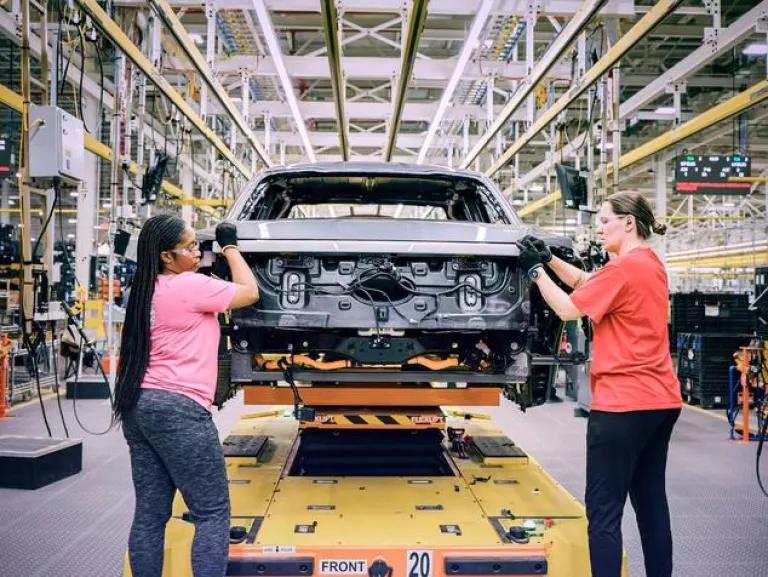 Shemika Winston (left) working on the 2022 Ford F-150 Lightning Pro electric pickup truck production line at the Electric Vehicle Center on the grounds of the Ford River Rouge complex in Dearborn, Michigan