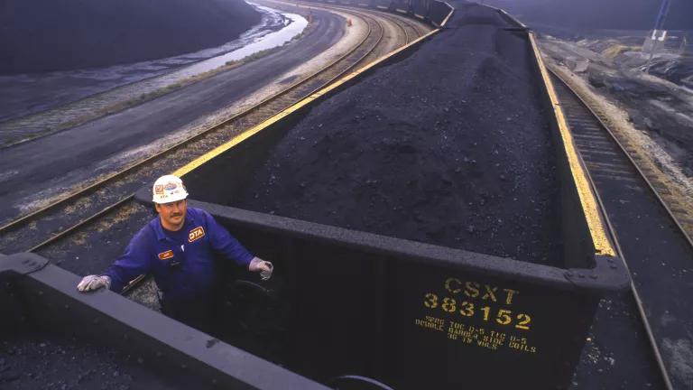 A worker standing between CSX coal cars at a coal shipping terminal in Newport News, Virginia on March 6, 1992.