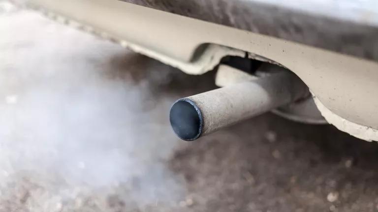 A dirty car tailpipe blows exhaust