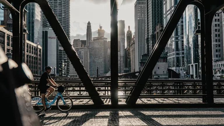 Man riding a bicycle on the bridge among skyscrapers