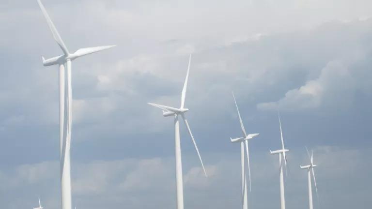 A row of wind turbines in a field