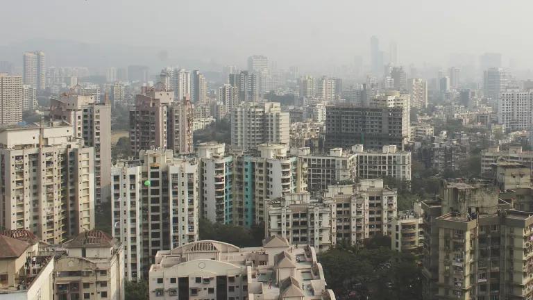 A thick gray smog hangs over a city skyline