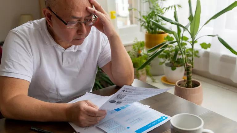 A man reviews his household utility bills.