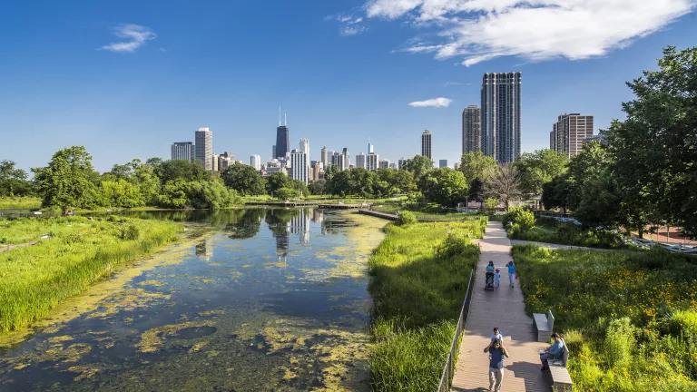 Families walking beside the South Pond at Lincoln Park in Chicago, Illinois.
