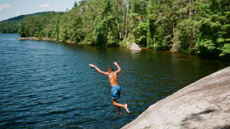 A boy jumping into a lake at Adirondack Park in New York.
