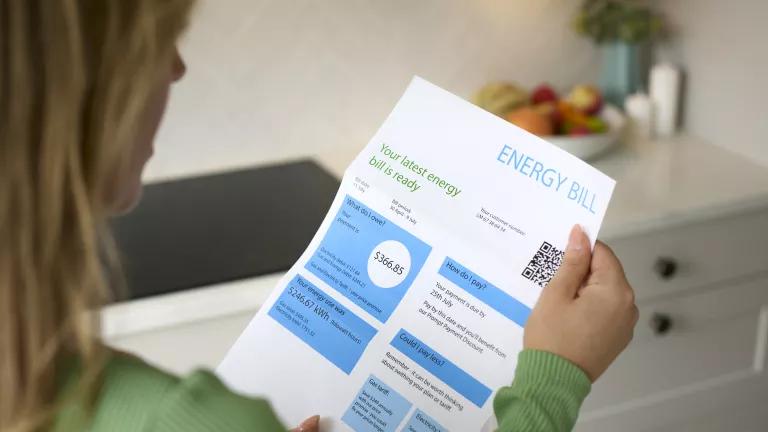 A woman looking at her monthly electricity bill.