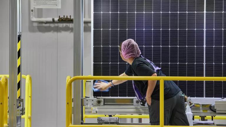 A technician examining a finished solar panel during quality control at the Hanwha QCells solar panel manufacturing plant in White, Georgia, on June 8, 2026. 

QCells' Cartersville factory is expected to have the capacity to manufacture 3.3 GW of ingots, wafers, and cells by the end of 2026.