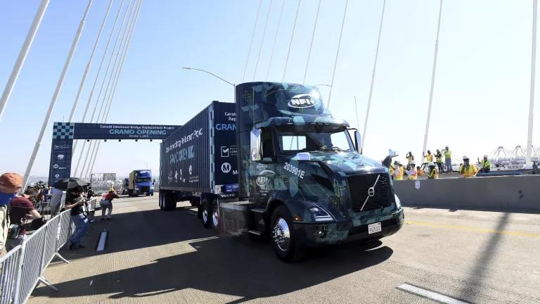 A blue 18-wheeler truck on a bridge