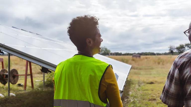 People discussing solar panel installation at a farm.