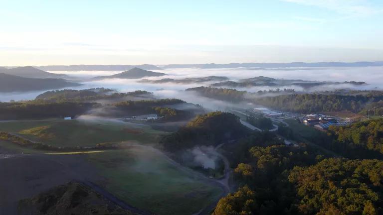 An aerial view of low mountains covered by fog