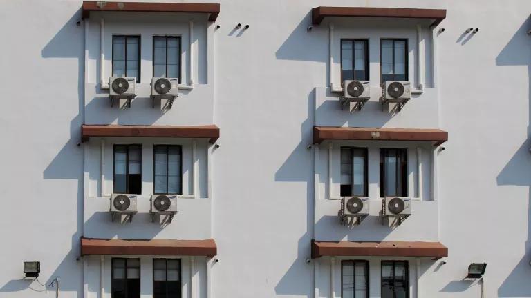 A white building with air conditioning units installed in each window