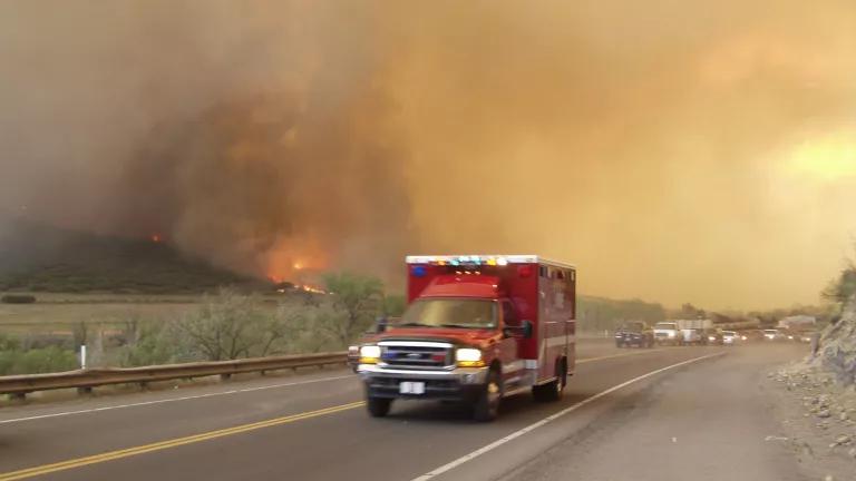 Ambulance speeding past fire evacuees