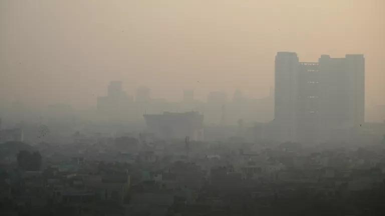 A city skyline is obscured by thick smog