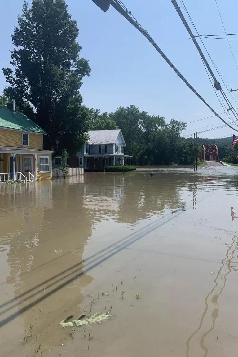 Two homes in Richmond Village, Montpelier, Vermont along the Winooski River during major flooding in 2023. The blue home belongs to Allison Palmer and her husband Nate. Due to flooding in 2023, they had to evacuate the home on multiple occasions.