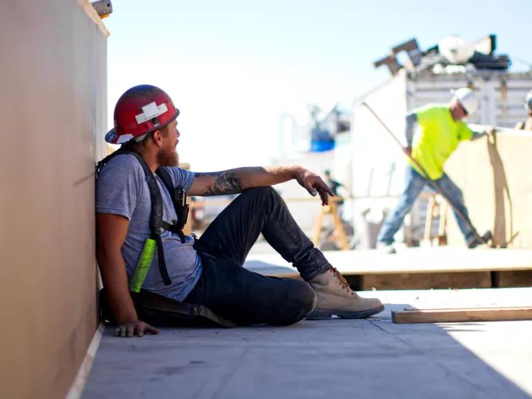 A worker taking a break in the shade at a construction site in Canada.