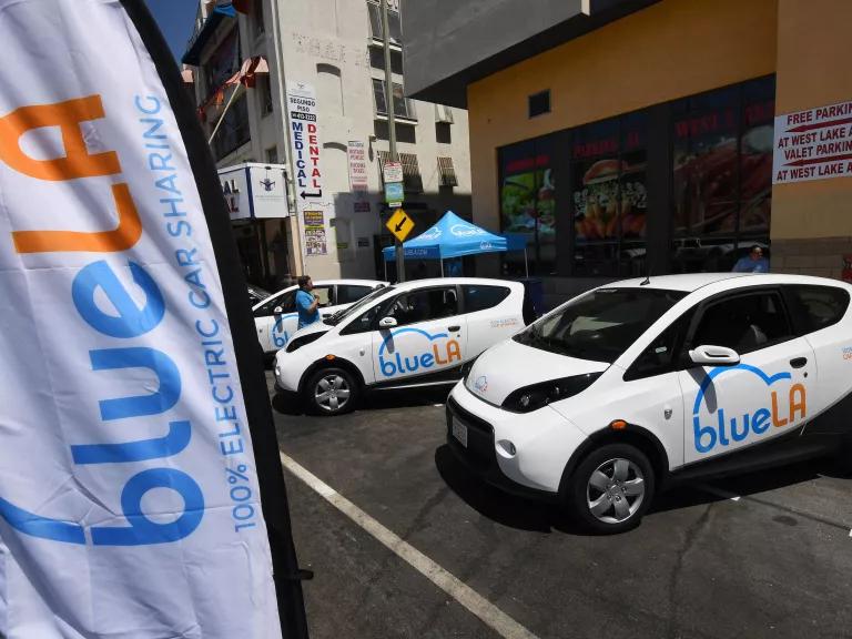 Three white electric vehicles at a charging station